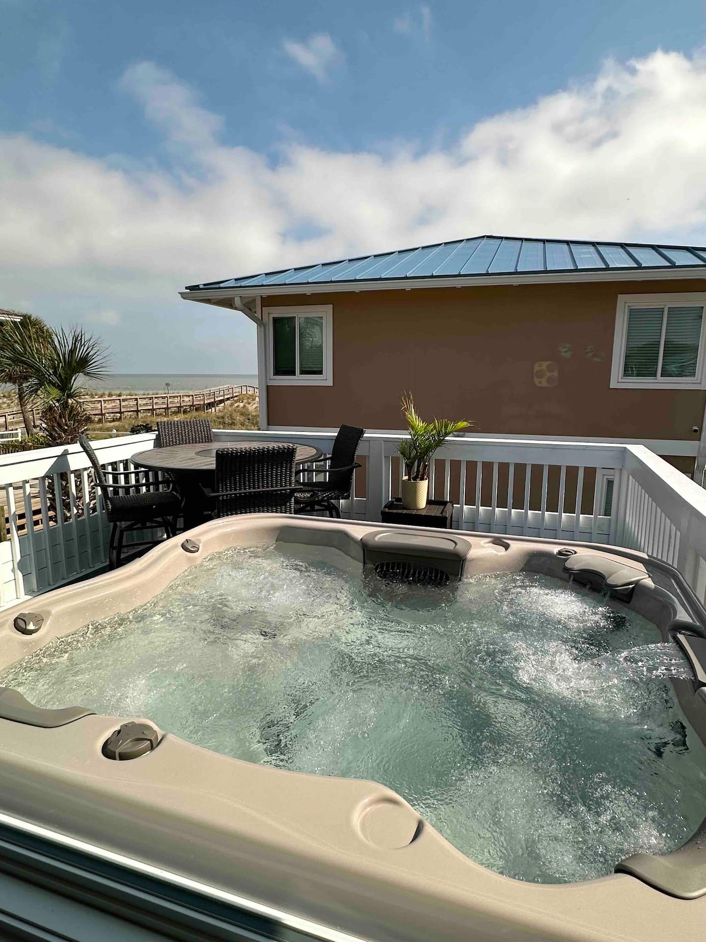Private balcony hot tub overlooking the beach at 47 Steps to the Beach